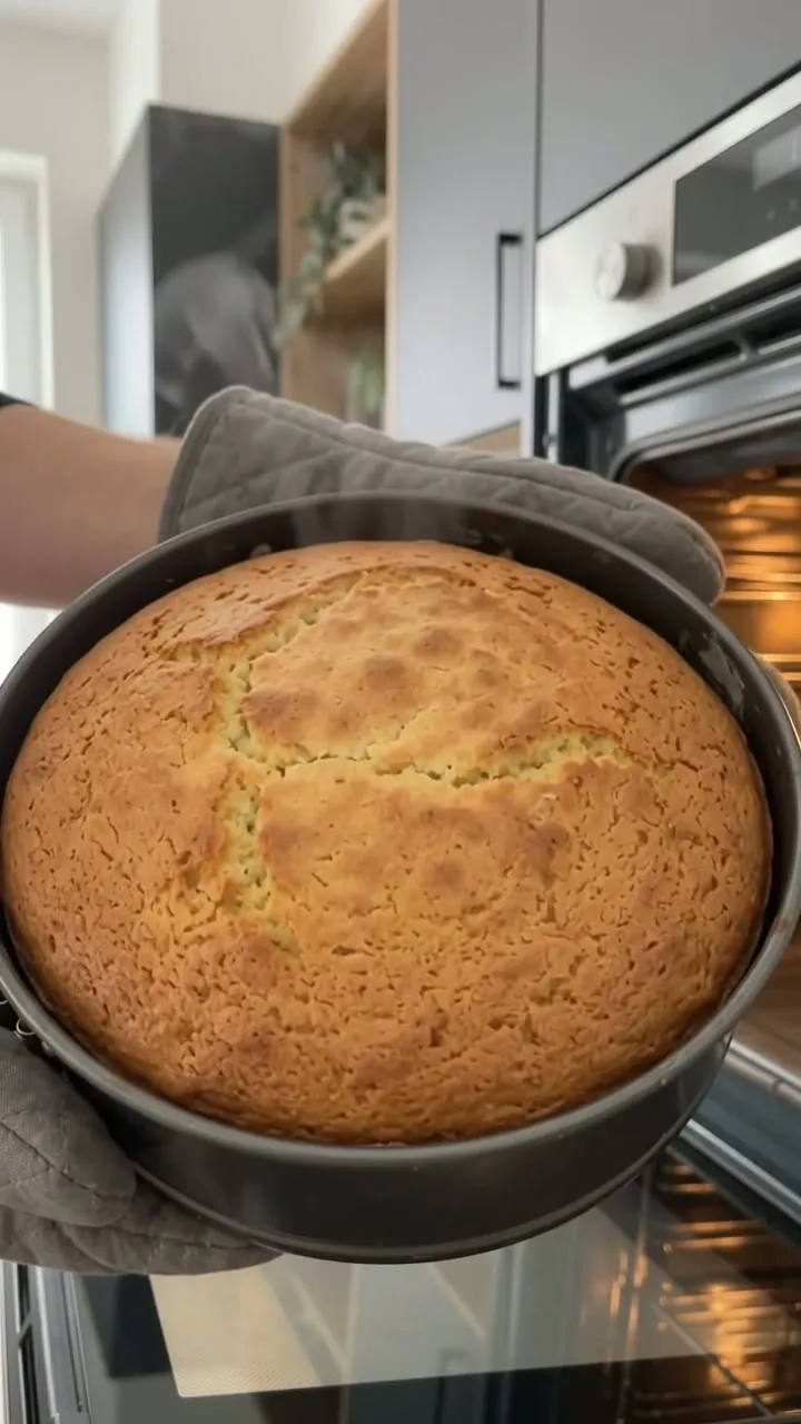 The apple cinnamon cake being taken out of the oven in its tin